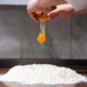 Pasta-making cracking an egg into 00 flour